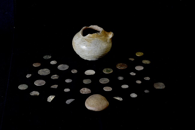 An image of the Glencoe coin hoard laid out on a black background and includes the pot and lid. Credit Gareth Beale 