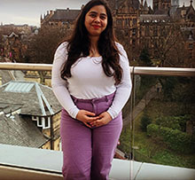 Student standing in front of the University of Glasgow