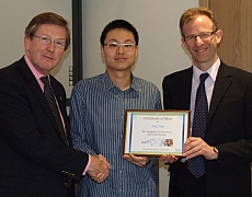 Sir Muir Russell, Principal of The University of Glasgow, presents Jing Jing, 24, with his certificate of merit with Robin Gordon, IBM’s Strategy & Business Development Manager, Scotland.