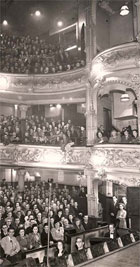 Black and white photograph of the audience at the Metropole Theatre (1862-1961), Stockwell Street, Glasgow c 1950. Side view showing three tiers, one of the boxes and part of the orchestra pit. (STA Ae10/3a-c) Links to collection description.