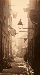 Black and white photograph of children sitting and standing in a narrow back lane, from Thomas Annan's The Old Closes and Streets of Glasgow, produced as a commission from the City of Glasgow Improvements Trust, c 1872. (Sp Coll Dougan 64, plate 13) Links to book of the month article.