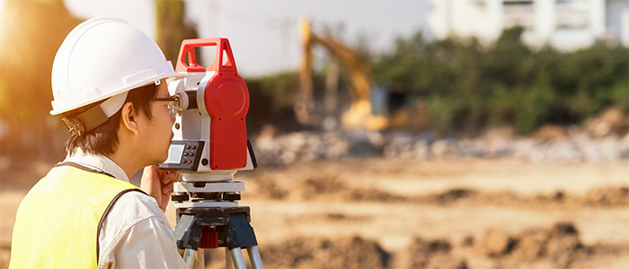 Surveyor engineer is measuring level on construction site