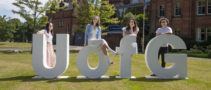 Students outside in Dumfries campus with UofG letters
