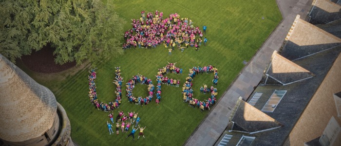 An aerial shot of a large group of people forming UofG in the quadrangle