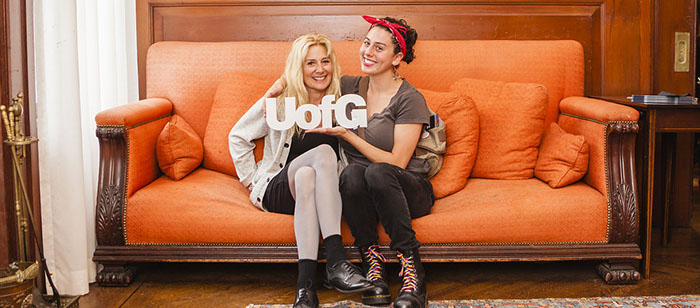 Two women on couch with small UofG