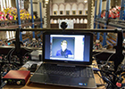 Image of Rector Edward Snowden on a lap-top screen in the Bute Hall