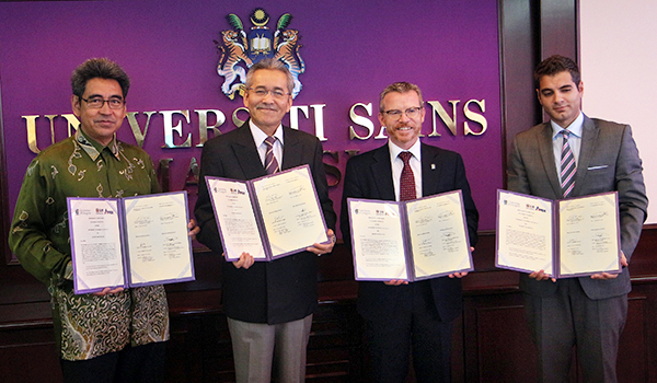 Frank Coton and representatives of the Universiti Sains Malaysia holding their signed copies of the new Memorandum of Understanding