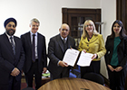 Image of NLU and University of Glasgow staff signing an MoU