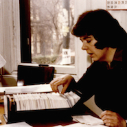 A photograph of a woman looking through index cards as part of the work on the Historical Thesaurus of English