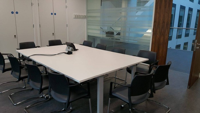Flat floored meeting room with boardroom tables and chairs and telephone