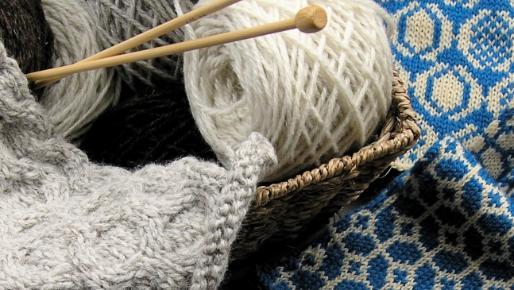 Close up image of yarn, knitting needles and knitting in progress