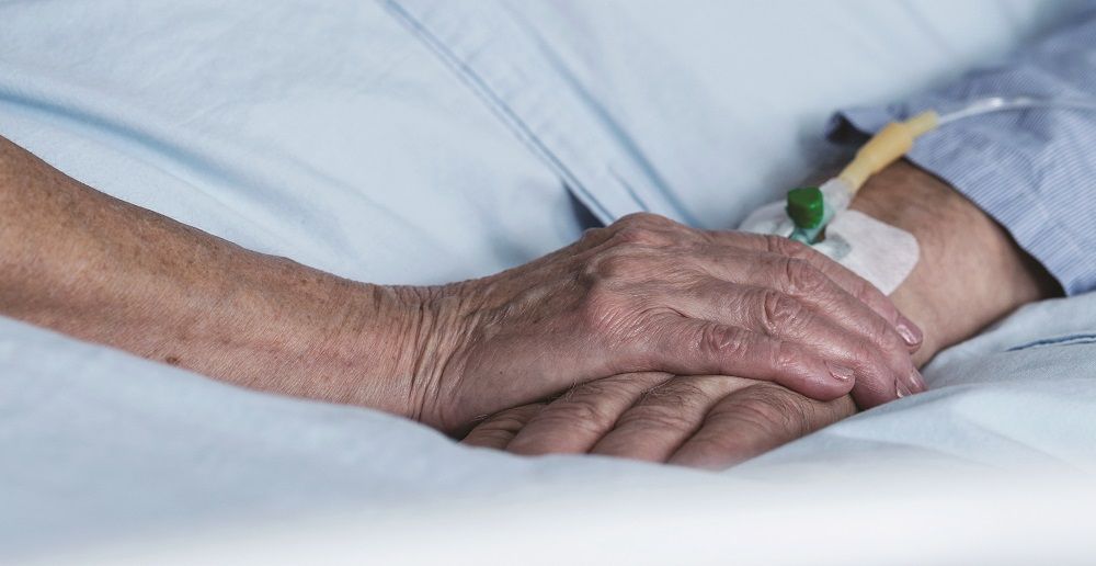 Nurse holding patients hand, Palliative Care