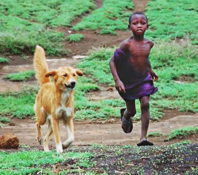 Small boy running with dog. Credit Katie Hampson