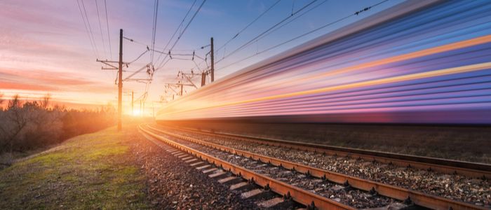Image of high speed passenger train in motion on railroad at sunset