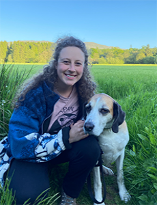 Image of Hannah Davies in a field with a large breed white dog