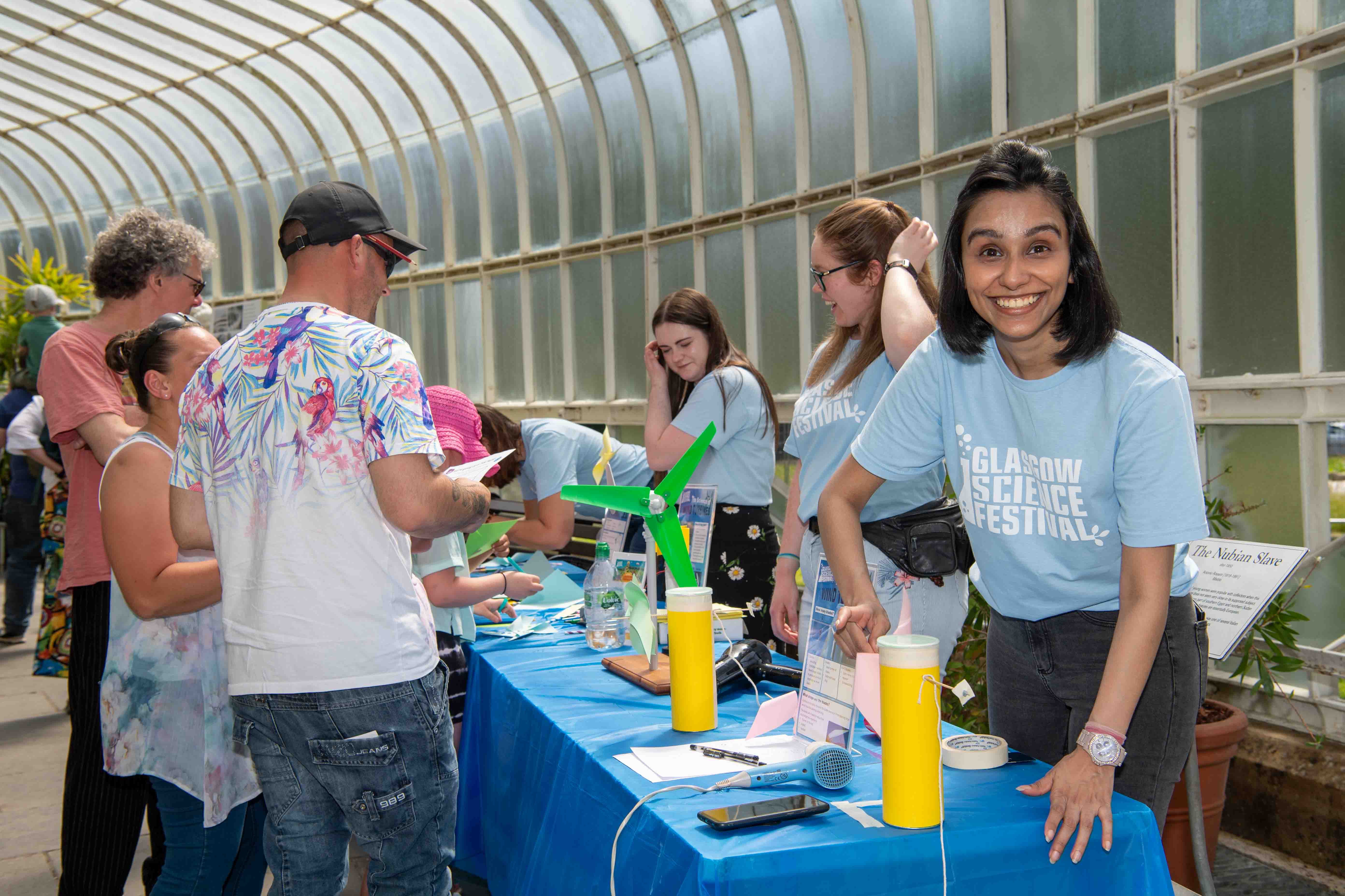 Photograph showing a GSF in Action student setting up the pinwheel experiment. In the background is the rest of the group helping to make pinwheels.