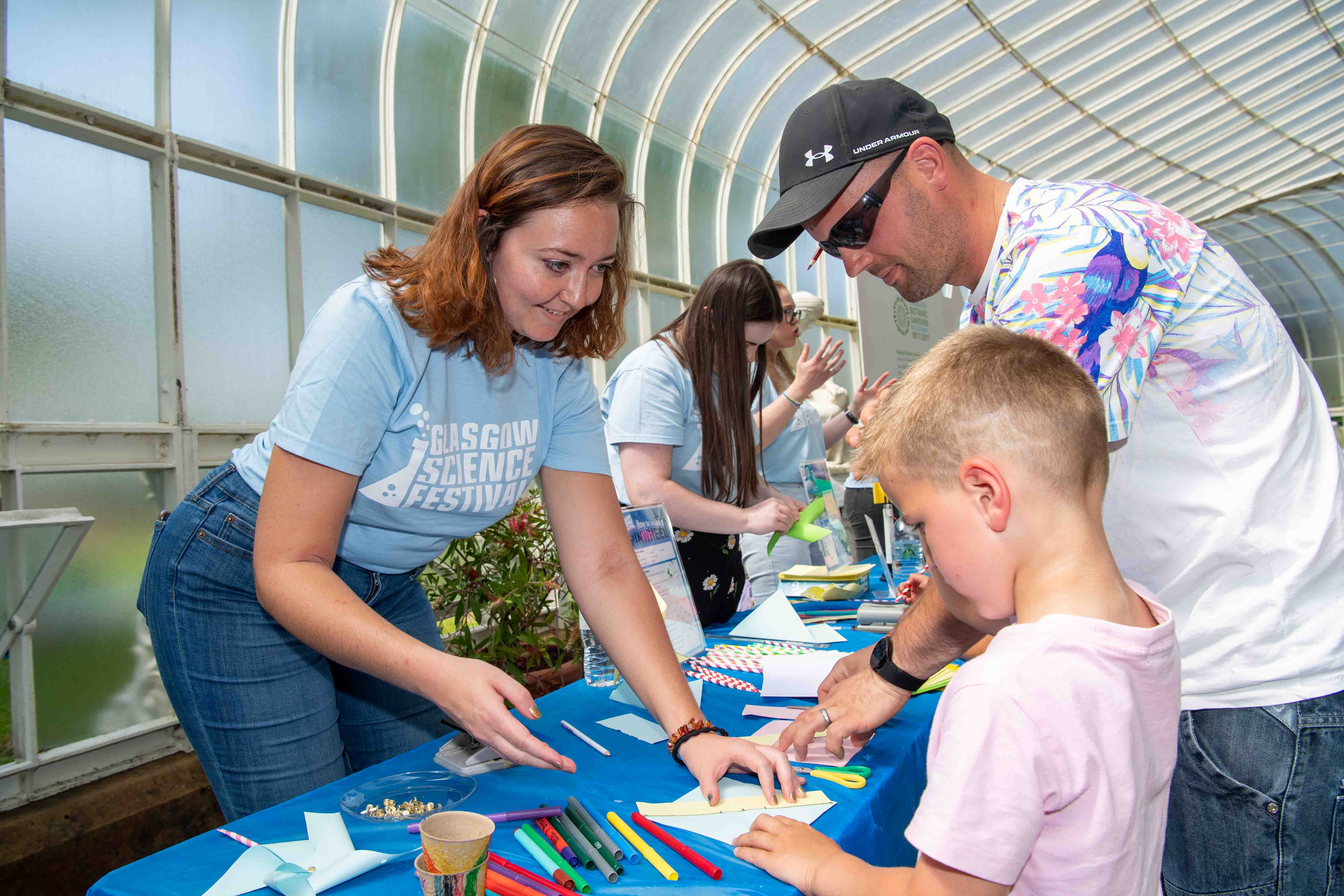 Photograph showing a GSF in Action student with a child helping to create a pinwheel.