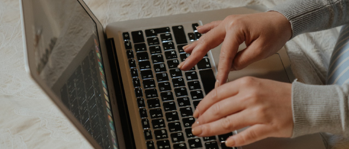 Stock image of hands typing on a laptop keyboard