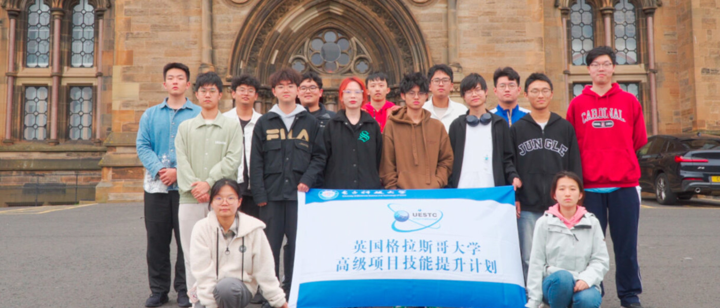 Group of Chinese Summer School students on UoG campus holding a flag