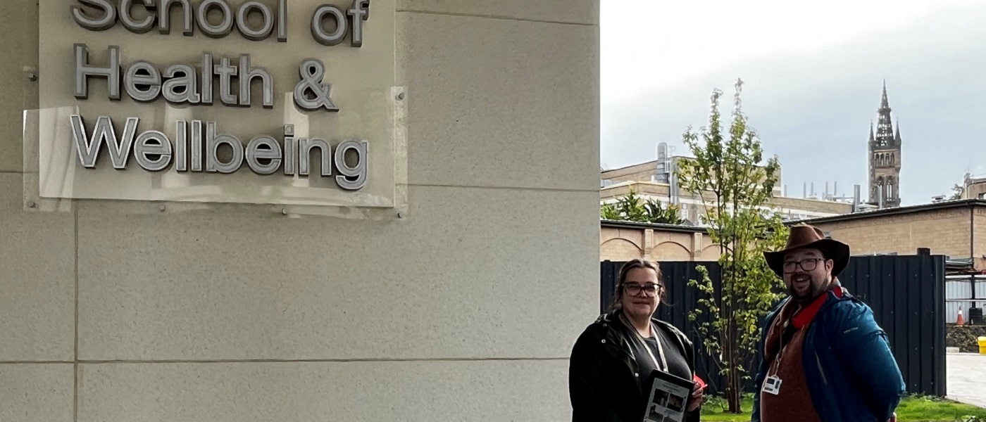 Two staff standing next to the sign for Clarice Pears building