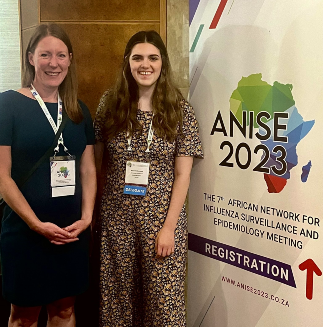 Two PhD students stood side by side in front of an ANISE pull up board