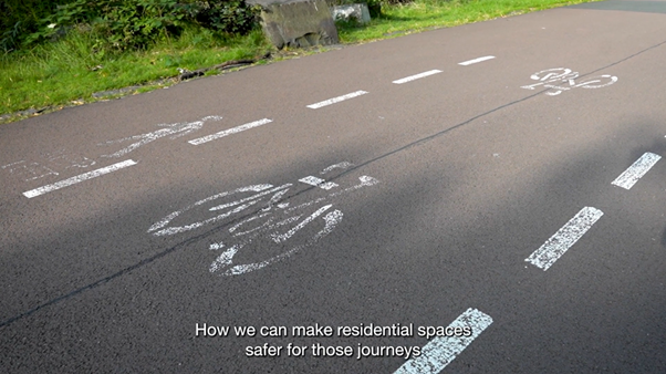 A close up of a bike lane beside a pedestrian lane on a road