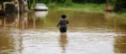 A boy stands waist deep in flood waters in Brazil.