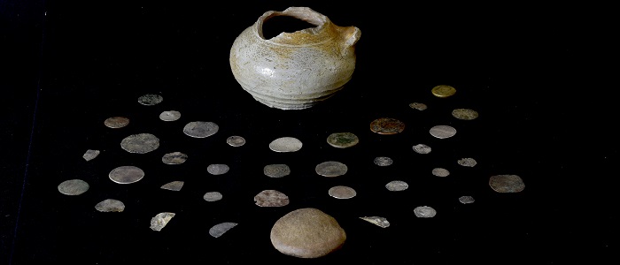 An image of the Glencoe coin hoard laid out on a black background and includes the pot and lid. Credit Gareth Beale