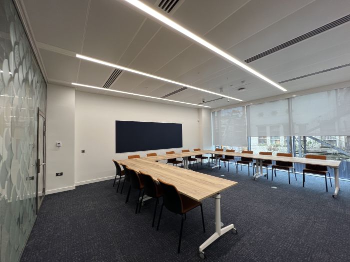 Flat-floored meeting room with tables and chairs in a horseshoe layout.