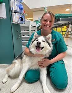 Image of Iona MacDonald wearing scrubs with a white dog