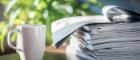 Photo of a mug of coffee and pile of journals 