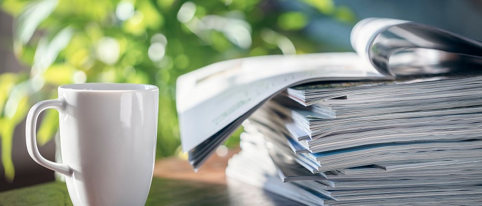 Photo of a mug of coffee and pile of journals