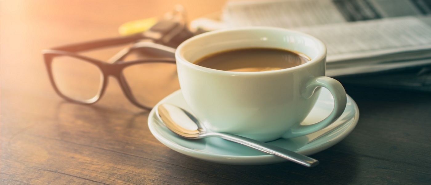 Photo of a cup of coffee, newspaper and spectacles
