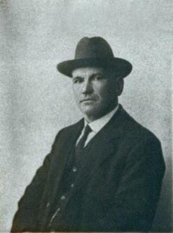  Black and white photo of Scottish revolutionary John Maclean in a suit and tie and wearing a hat: Source: Wikimedia https://en.wikipedia.org/wiki/File:John_MacLean_passport.jpg 