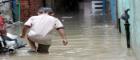 Young boy walks through floodwaters   