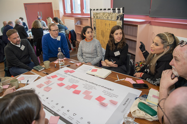 A group of volunteers discuss suggestions for the Thriving Glasgow Potrait at a workshop event held in the city