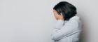 Woman has her head in her hands, looking stressed