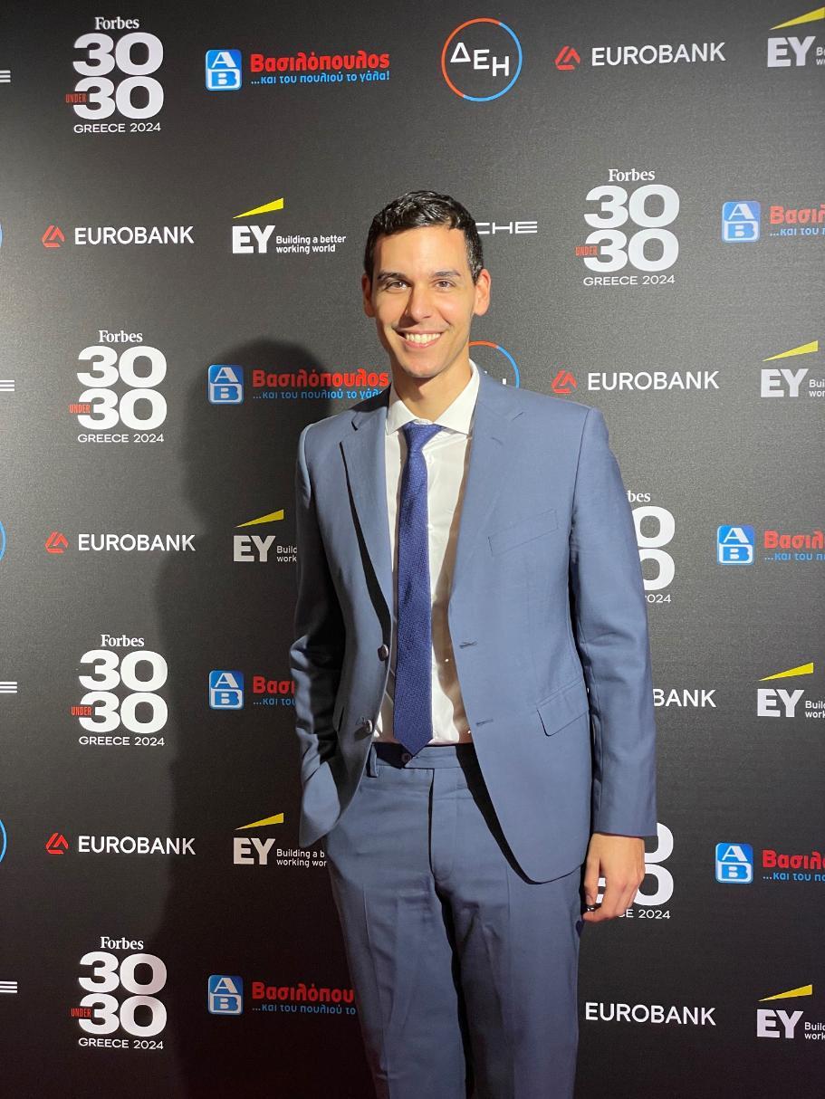 A man standing before a backdrop of sponsor logos