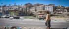 A child looks at the ruins of houses around him in Yemen.