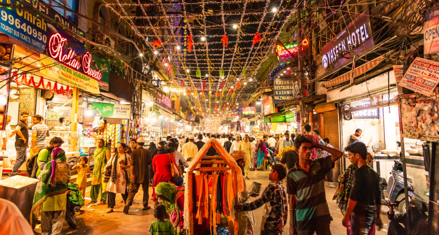 People in Urdu Bazar or market street of historical part of Chandni Chowk locality of Old Delhi in the evening [Photo: Shutterstock]