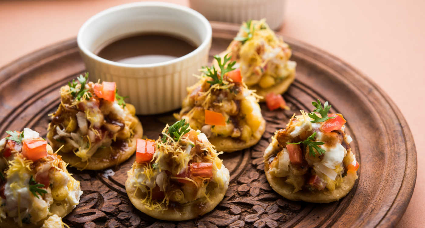 Papdi chaat street food on a platter with a dip (crackers layered with curd, chutney and spices) [Photo: Shutterstock]
