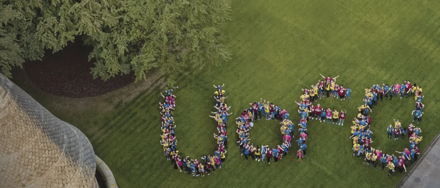 Aerial shot of UofG letters made up by students standing in formation