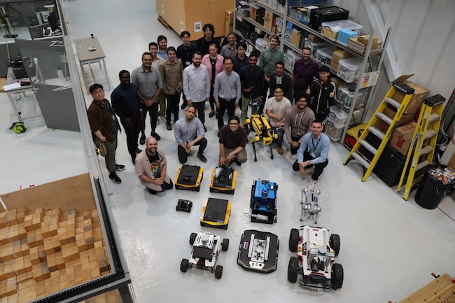 The research team onsite at RAICo with the robots that make up the prototype nuclear cleanup SMuRF