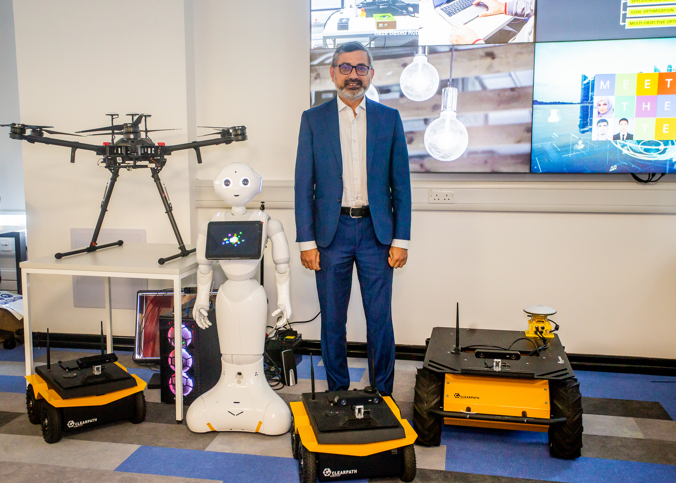 Professor Muhammad Imran with some of the CSI group's robots and a drone