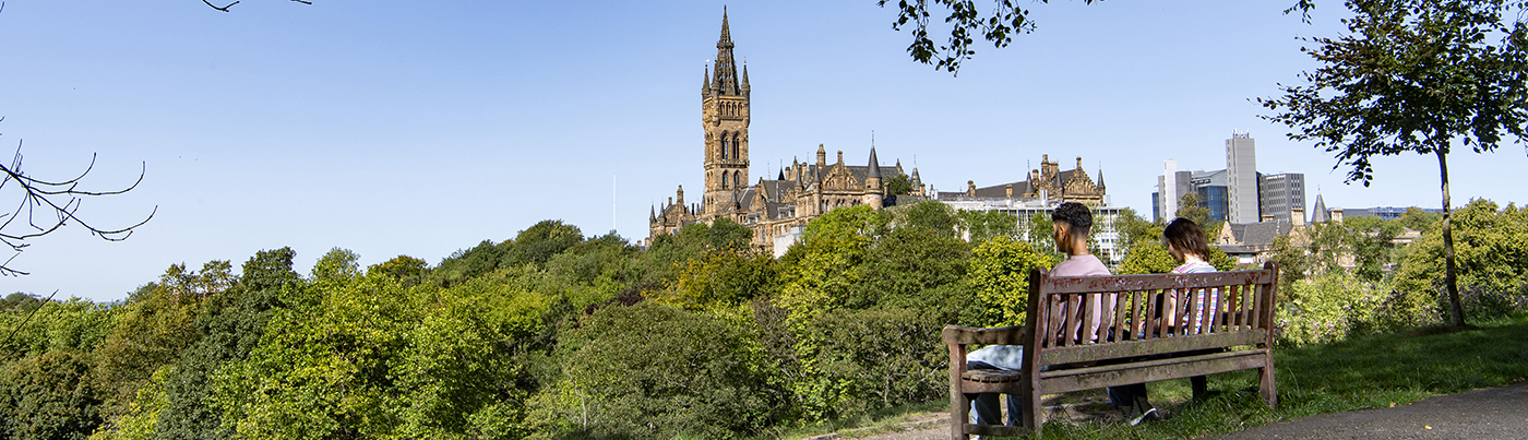 Students in Kelvingrove Park, with University of Glasgow in the distance