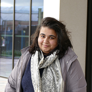 Mridula Duggal, Adam Smith Career Development Fellow, standing outside the Adam Smith Building in Glasgow