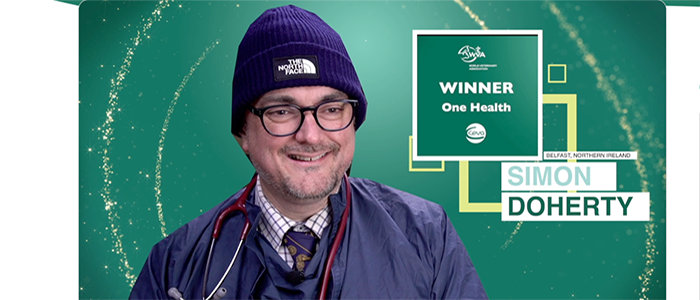 Image of Dr Simon Docherty wearing vet gear on a WVA banner for the One Health Award