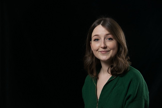 Portrait of a woman sitting with a black background