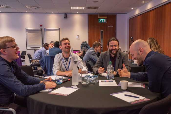 Group at a table networking at the IAA Impact Festival 2023