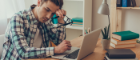 Man sits at his desk looking dejected